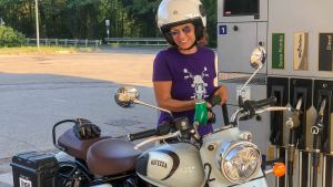 Woman refueling a Royal Enfield Classic 350 from Motezza at a gas station in Italy.